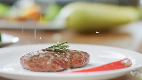 Sprinkle salt on appetizing beef piece serving on plate slow motion. Close up Video stock 124155251