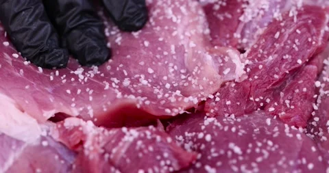 Sprinkle with salt sliced piece of fresh raw pork ,during salting, preparation Stock Footage 264865601