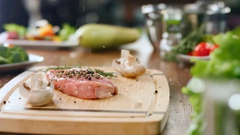 Sprinkle spice on delicate meat fillet slowmo. Medium close up shot on 4k RED Stock Footage 124155137