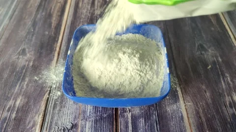 Sprinkle wheat flour on top of a blue plastic bowl Stock Footage 232219716