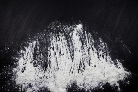 Sprinkle of white flour on black surface 写真素材
