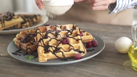 Sprinkle white icing sugar on baked Belgian waffles. A beautiful plate of ho Vídeo Stock 154150054