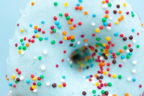Sprinkled blue donuts on blue background Stock Photos