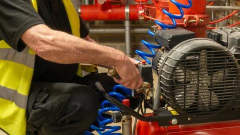 Sprinkler engineer servicing a compressor on a fire protection system Foto stock