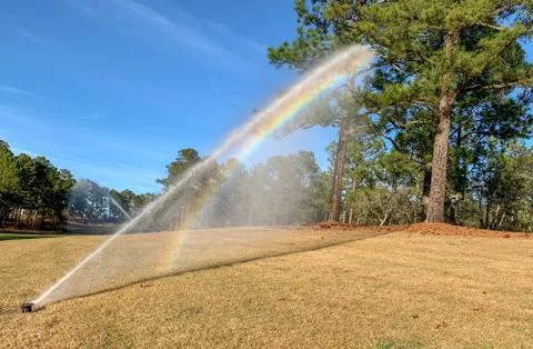 Sprinkler on the Golf Course with rainbow Stock Photos