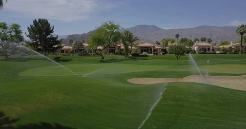 Sprinkler spray drifting over a Coachella Valley golf green Stock-Footage 74734735