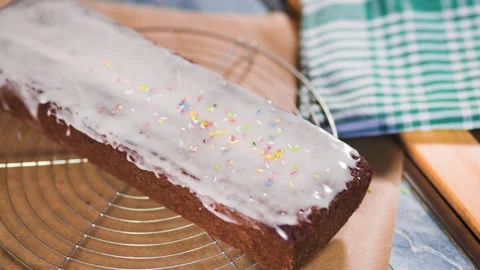 Sprinkles fall on cake with white icing 스톡 동영상 334346686