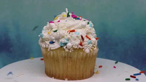Sprinkles falling on spinning cupcake Stock Footage 238607973