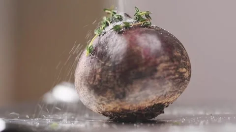 Sprinkling of the beetroot with salt before roasting, slow motion. Stock Footage 154328616