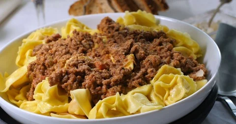 Sprinkling black pepper over delicious steamy tortellini in bolognese sauce Stock Footage 74069811
