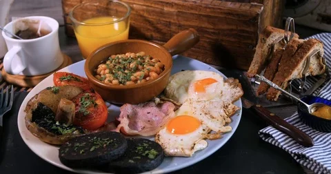 Sprinkling black pepper over a full cooked English breakfast Stock Footage 73136225