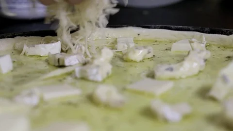 Sprinkling the cheese on the pizza surface Stock Footage 114292589