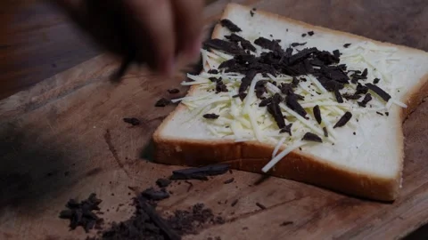 Sprinkling chopped chocolate on top of the bread Stock Footage 287681824