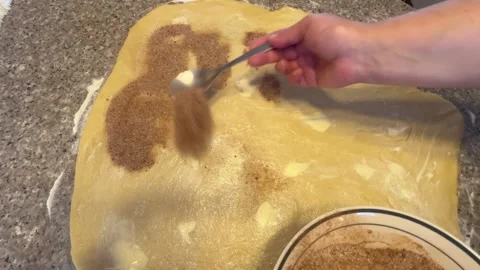 Sprinkling Cinnamon Sugar on Buttered Dough for Pastry Making Video stock 345522395