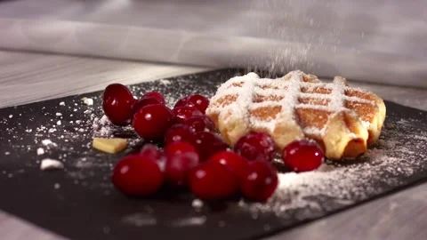 Sprinkling dusting of sugar on waffles with ripe cranberries Video stock 336955203
