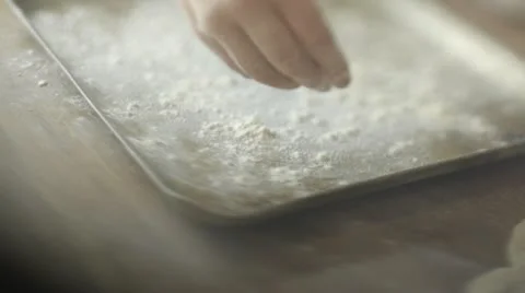 Sprinkling flour on baking tray Stock Footage 12592091