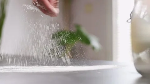 Sprinkling flour on the table, slow motion. Stock Footage 154937187