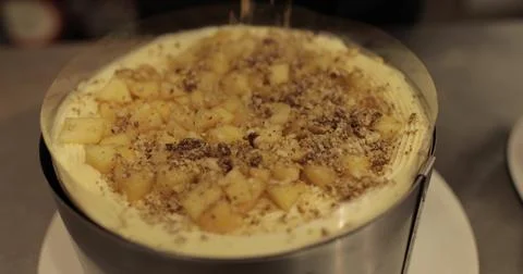 Sprinkling ground nuts on the cake during cooking. A professional confectio.. Stock Photos