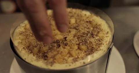 Sprinkling ground nuts on the cake during cooking. A professional confectio.. Stock Photos