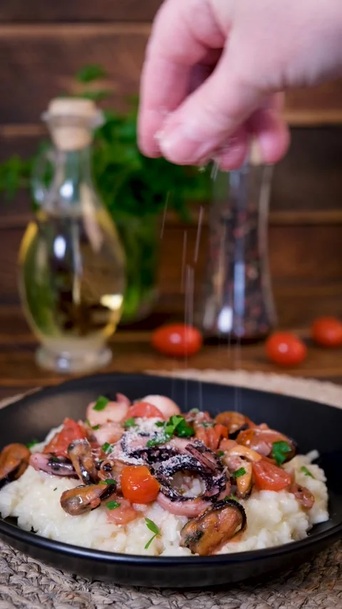 Sprinkling Parmesan on Seafood Risotto Vertical Video Stock Footage 337158535