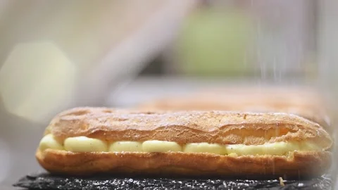 Sprinkling powdered sugar on the eclair. Stock Footage 154369347