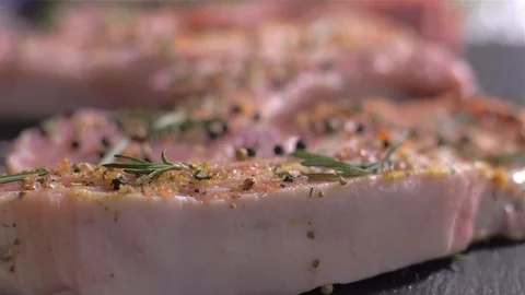 Sprinkling of raw pork chops with bone with a mix of spices Stock Footage 106472929