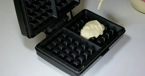 Sprinkling rectangular wafers in a waffle iron, making sweets from soft wafers. 스톡 동영상 231570002