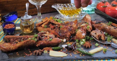 Sprinkling red chilly flakes over delicious braised sticky king pork ribs Stock Footage 75779702