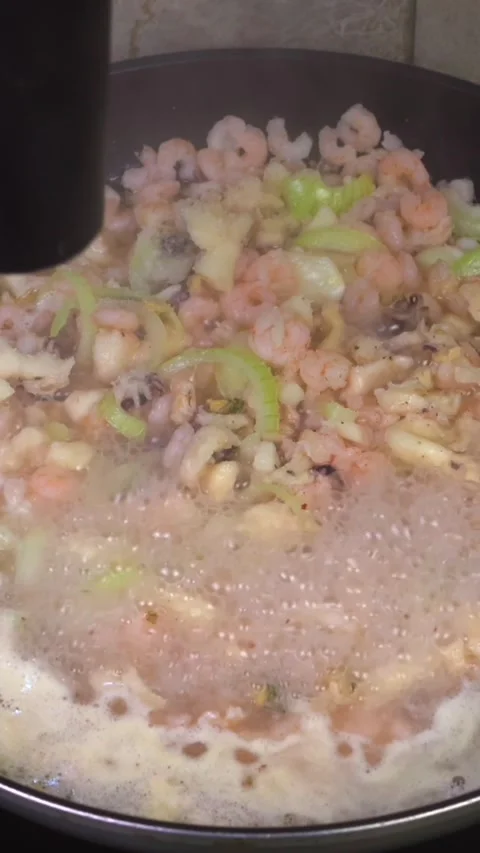 Sprinkling salt grinding pepper then mixing cooked rice into seafood pan Stock Footage 343460181