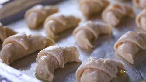 Sprinkling sugar cane on raw dough for croissants on an aluminium paper Stock Footage 128805165