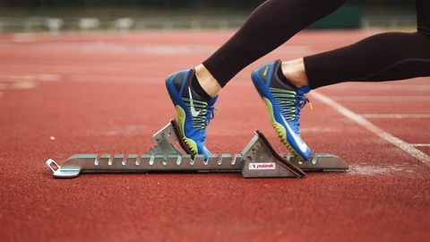 Sprinter getting in the blocks and starting the run [6K50p] Track and Field Stock-Footage 127117443