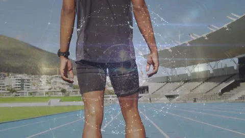 Sprinter lowering hands, stepping to starting blocks on blue track, sports Stock Footage 330980823