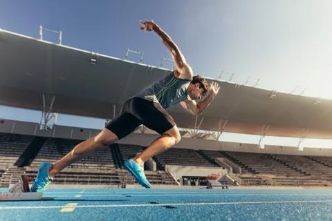 Sprinter taking off from starting block on running track Stock Photos