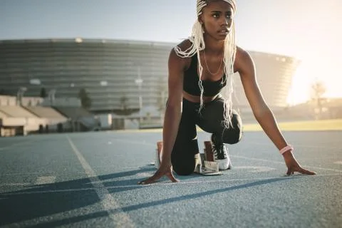 Sprinter using a starting block to start her sprint on a running track Stock Photos