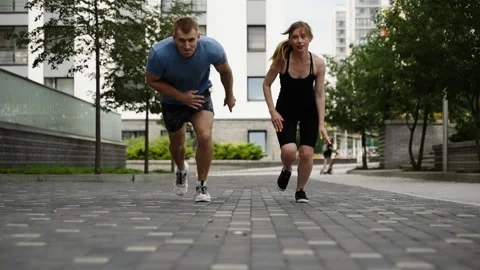 Sprinters start running against the background of residential buildings. Slow Stock Footage 254230724