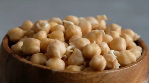 Sprouts or seedlings of chickpea beans in a wooden bowl, close up. Vegan diet Stock Footage 127386486