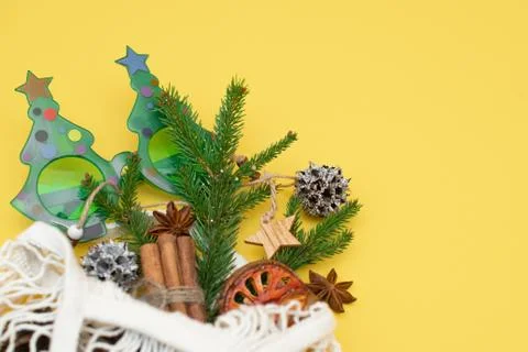 Spruce branch in an eco-friendly string bag and Christmas decorations on a Stock Photos