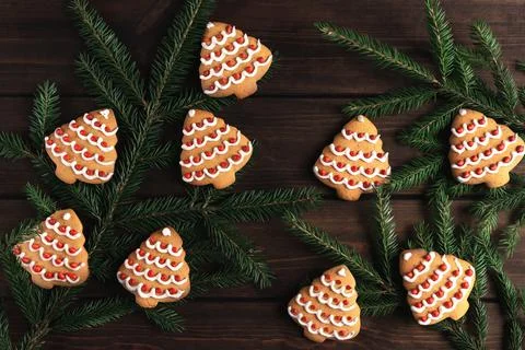 Spruce branches and many cookies shaped christmas tree on a dark wooden backg Stock Photos