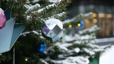 Spruce branches with snow on it and Christmas toys in the foreground and wint Stock Footage 139850057
