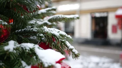 Spruce branches with snow on it and Christmas toys in the foreground and wint Stock Footage 139850061