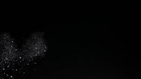 Spurt of rough particles blown from side of frame then hang suspended in the air Vídeo Stock 76464758