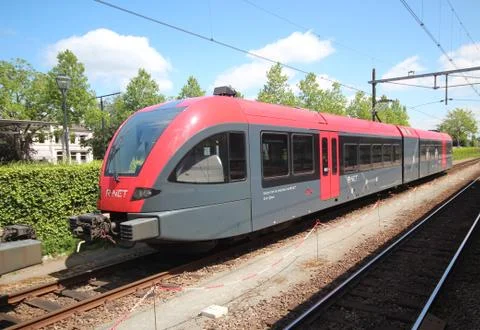 Spurt train in red and black of R-NET on Merwedelingelijn along platform at s Stock Photos