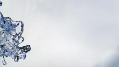 Spurting water falling down in front of white background with blue reflection Video stock 98701027