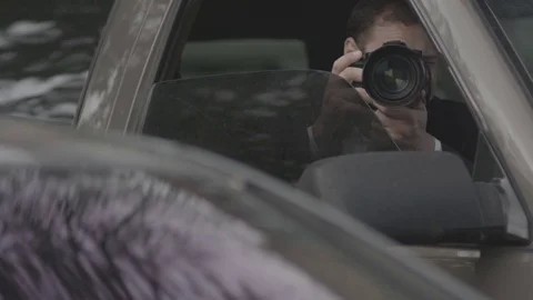 Spy, paparazzi or detective in the car, shooting on camera. Stock Footage