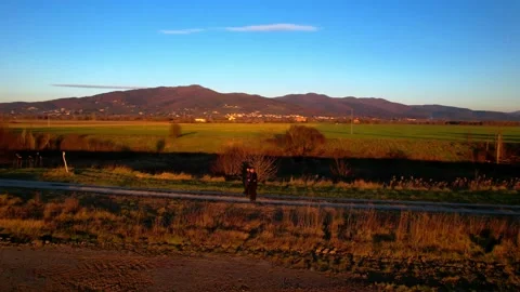 Spyral orbiting out Sunset walking Dad&amp;Son along stream path 4K Italy Tuscany Stock-Footage 234143512