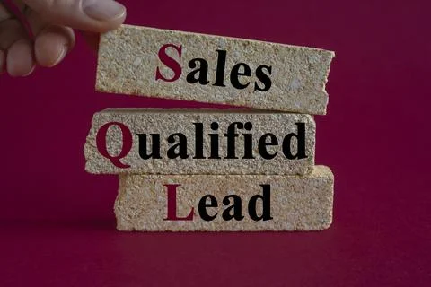 SQL - Sales Qualified Lead. Brick blocks with words SQL. Businessman hand. Stock Photos