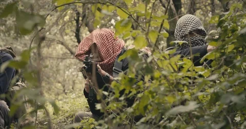 Squad of armed islamic isis terrorists patrolling a forest area during combat Vidéo 106684059