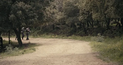 Squad of armed islamic isis terrorists patrolling a forest area during combat Stock Footage 106684317