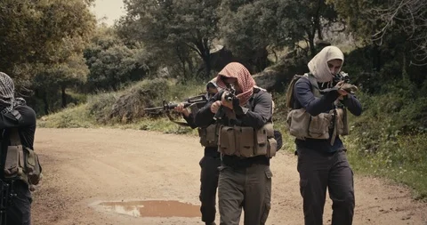 Squad of armed islamic isis terrorists patrolling a forest area during combat Vidéo 106684378