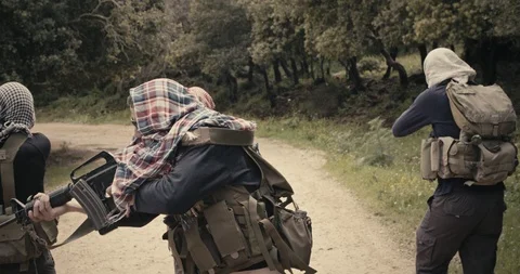 Squad of armed islamic isis terrorists patrolling a forest area during combat Vidéo 106684400